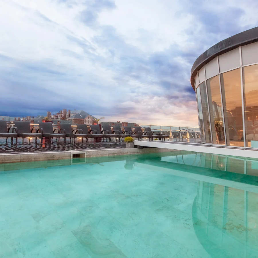 Piscina exterior junto a la rotonda vidriada al atardecer
